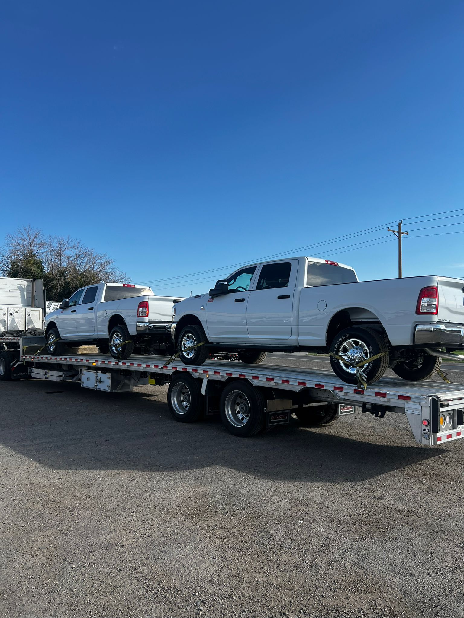 Two Dodge RAM 2500 Pickups loaded for transport