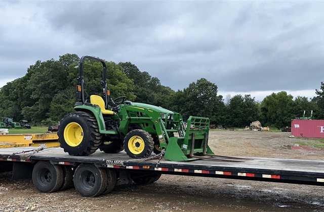 John Deere Tractor with 300E Loader — A green John Deere compact tractor carries a 300E front-loader assembly.