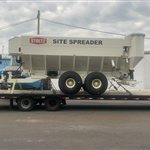 Towable Stoltz Site Spreader — A white Stoltz Site Spreader with its own axle group and towing frame is shown from two angles. View 2.