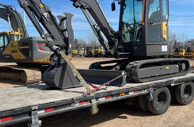 Volvo Compact Excavator — A compact Volvo excavator is photographed with its boom folded, blade lowered and bucket supported on the trailer.