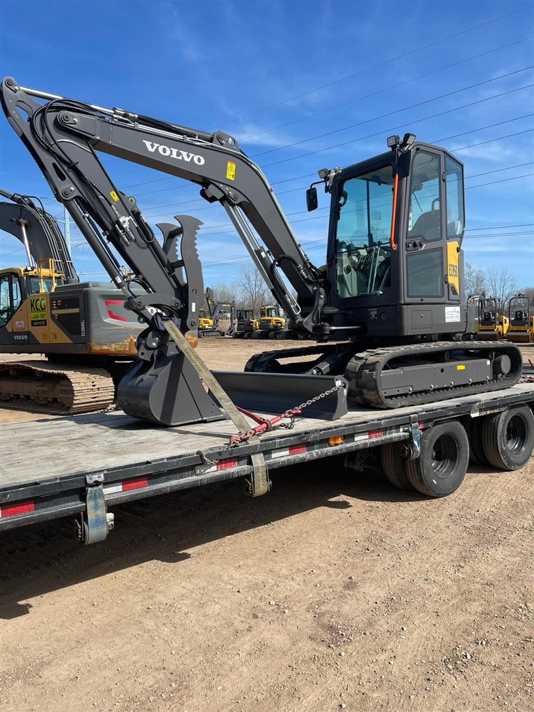 Volvo Compact Excavator — A compact Volvo excavator is photographed with its boom folded, blade lowered and bucket supported on the trailer.