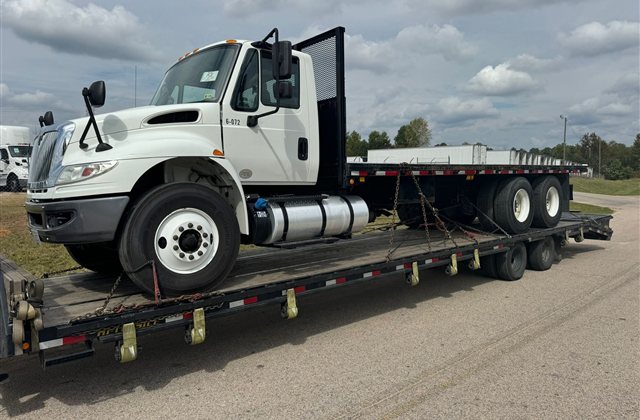 International Flatbed Truck: A white International truck photographed with its open working chassis and body