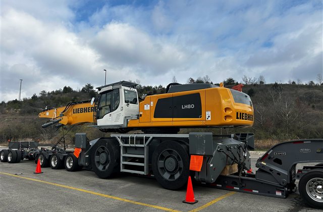 Liebherr LH 80 Material Handler: A large wheeled material handler with its handling boom folded for transport (view 1)